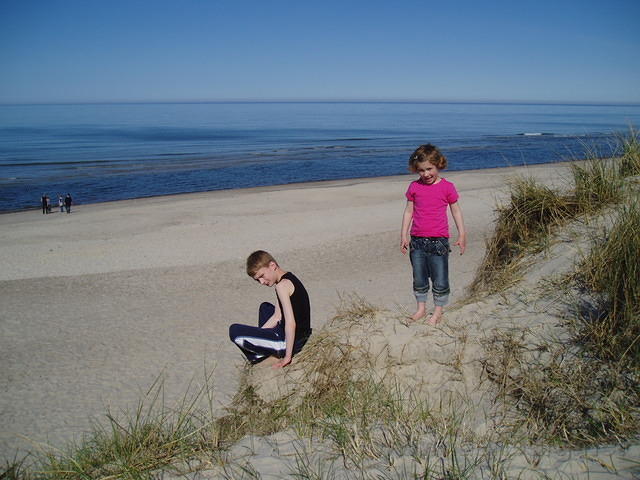 Het strand, twee kleuters op het duin.