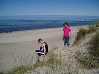 Het strand, twee kleuters op het duin.